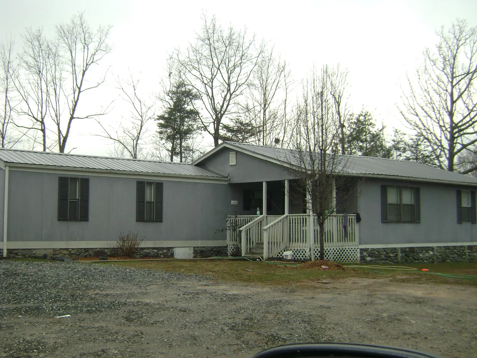 Metal roof over a manufactured home with a covered front porch in Cresson
