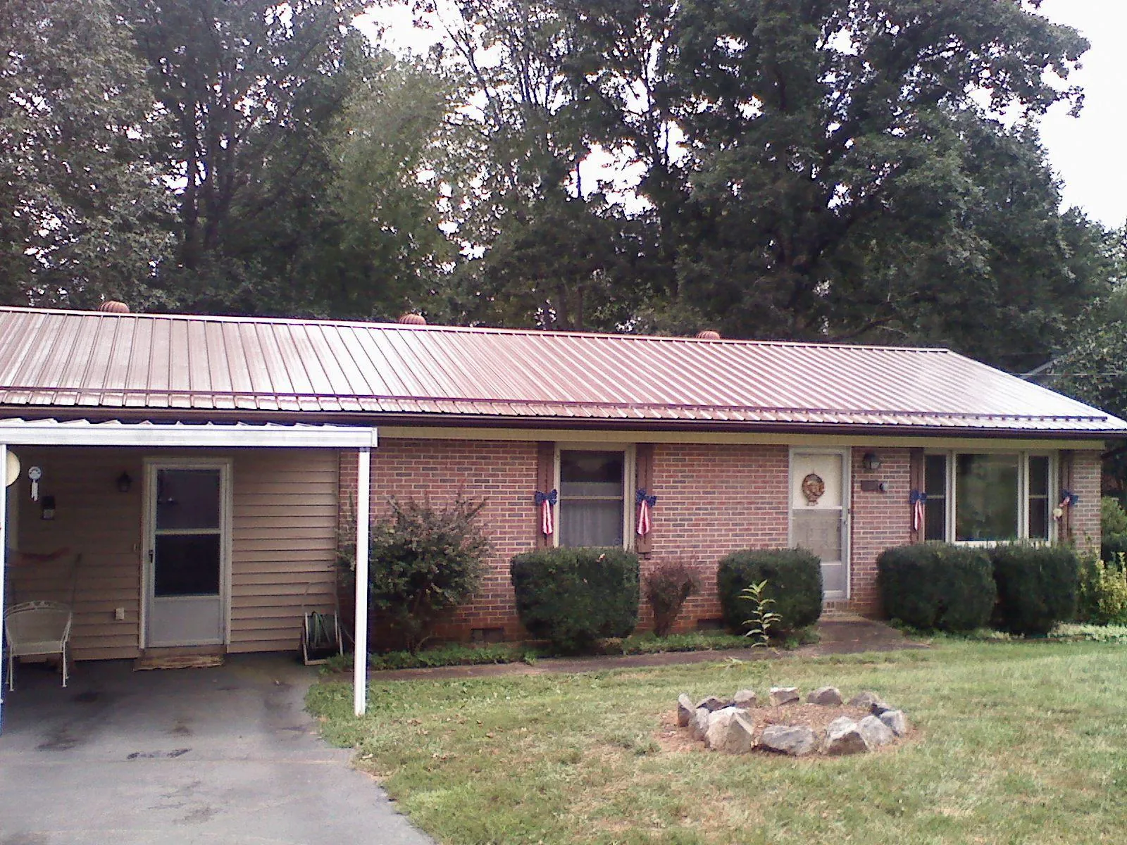 Bronze metal roof and carport on a brick ranch home — Roof Repair work by our crew in Cresson